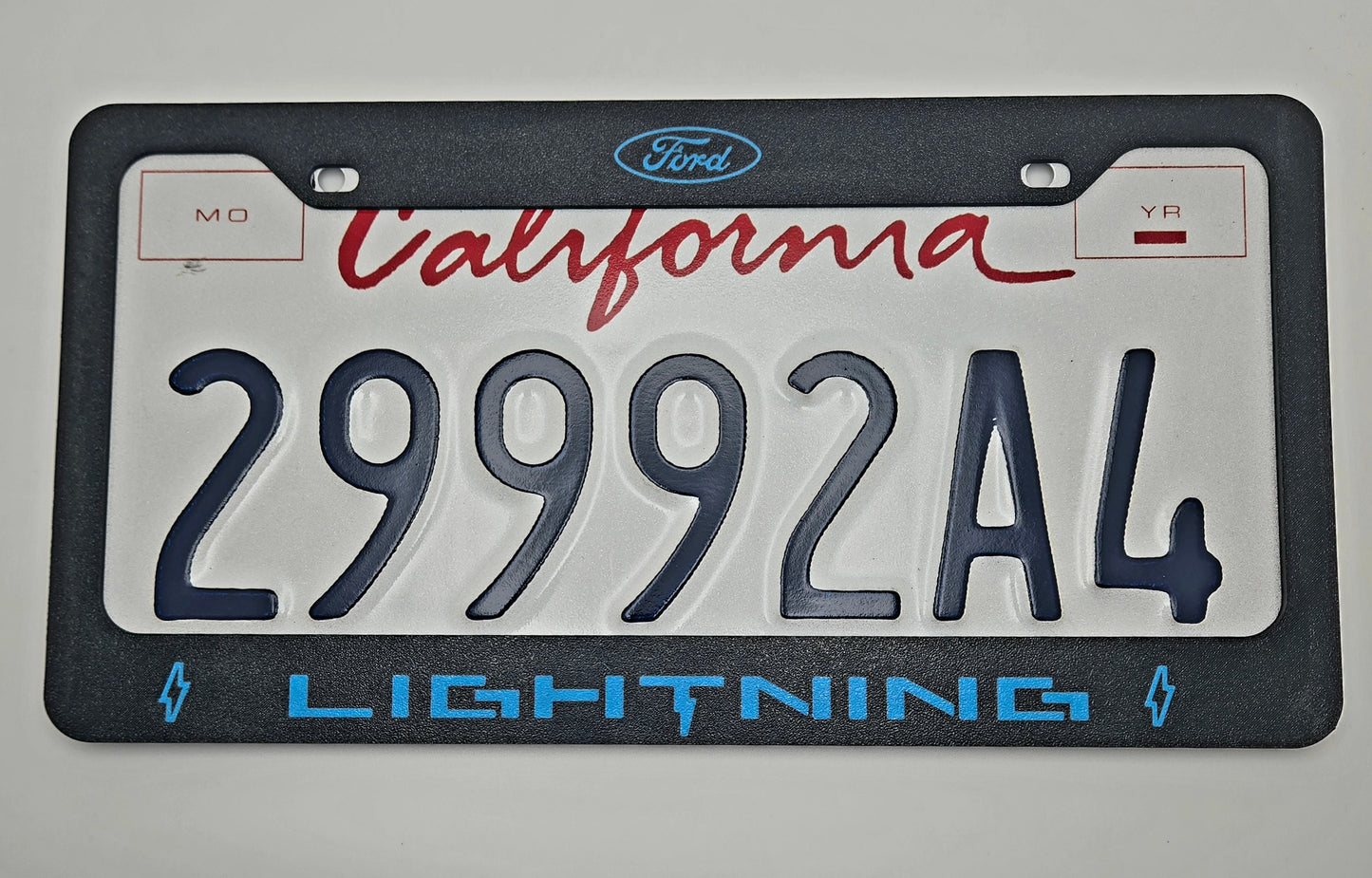 Ford Lightning license plate frame lightning blue with plate logo close-up