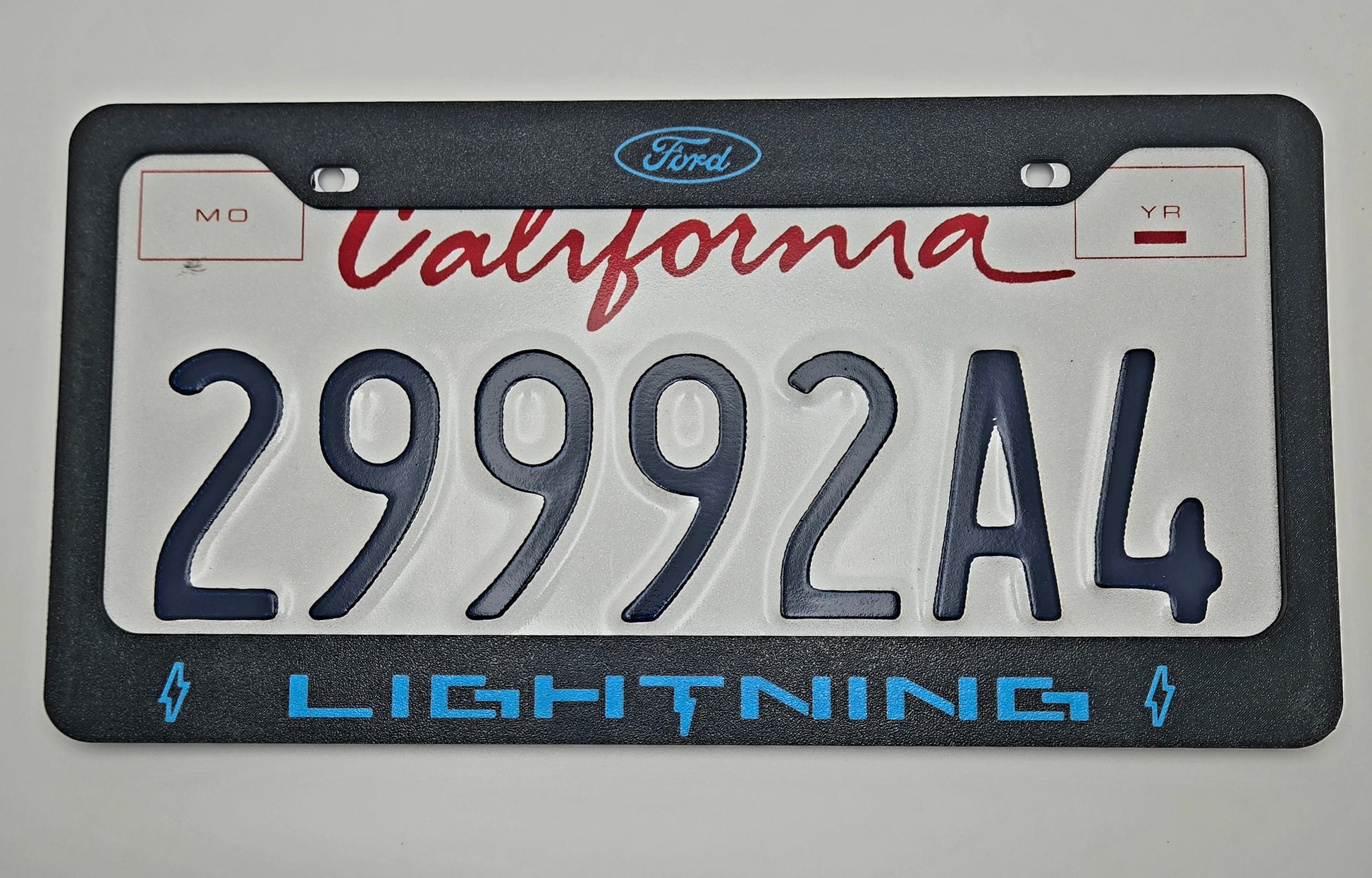 Ford Lightning license plate frame lightning blue with plate logo close-up